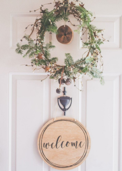 A door with a wreath and a welcome sign